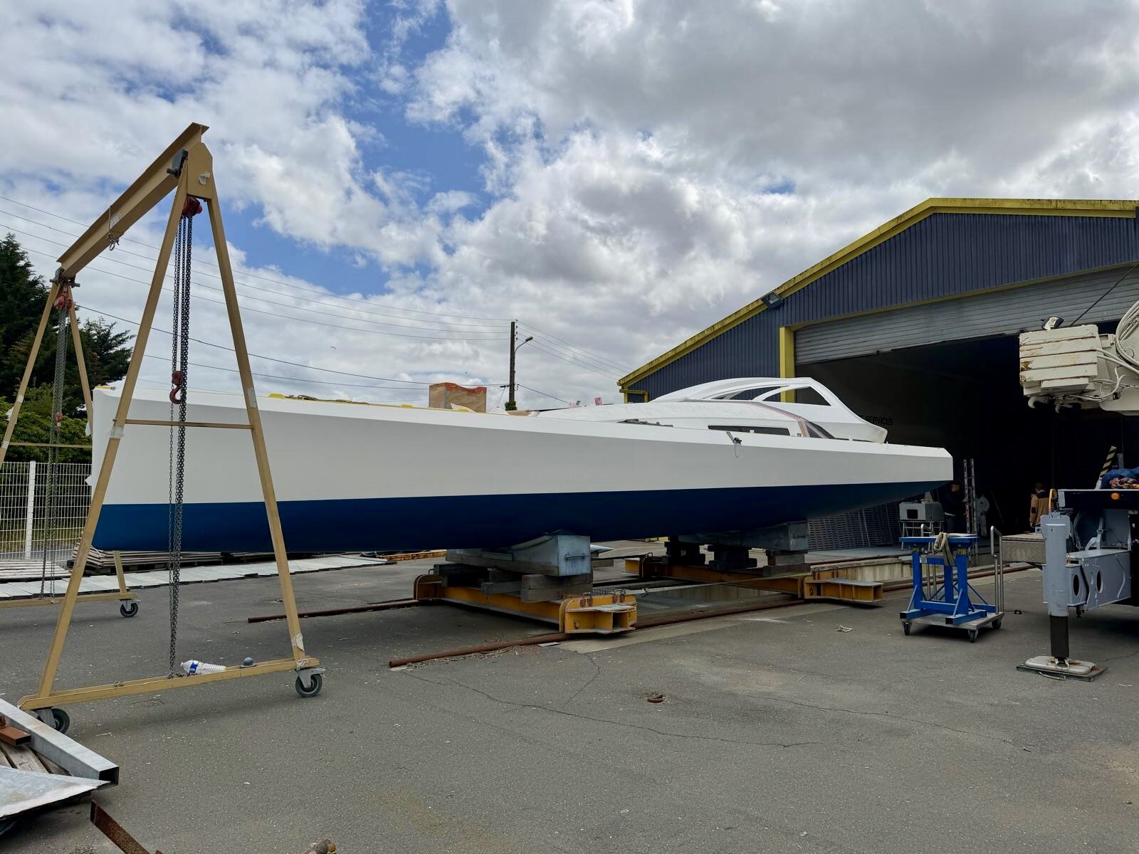 Guerrera's finished white hull with navy bootstripe outside the yard