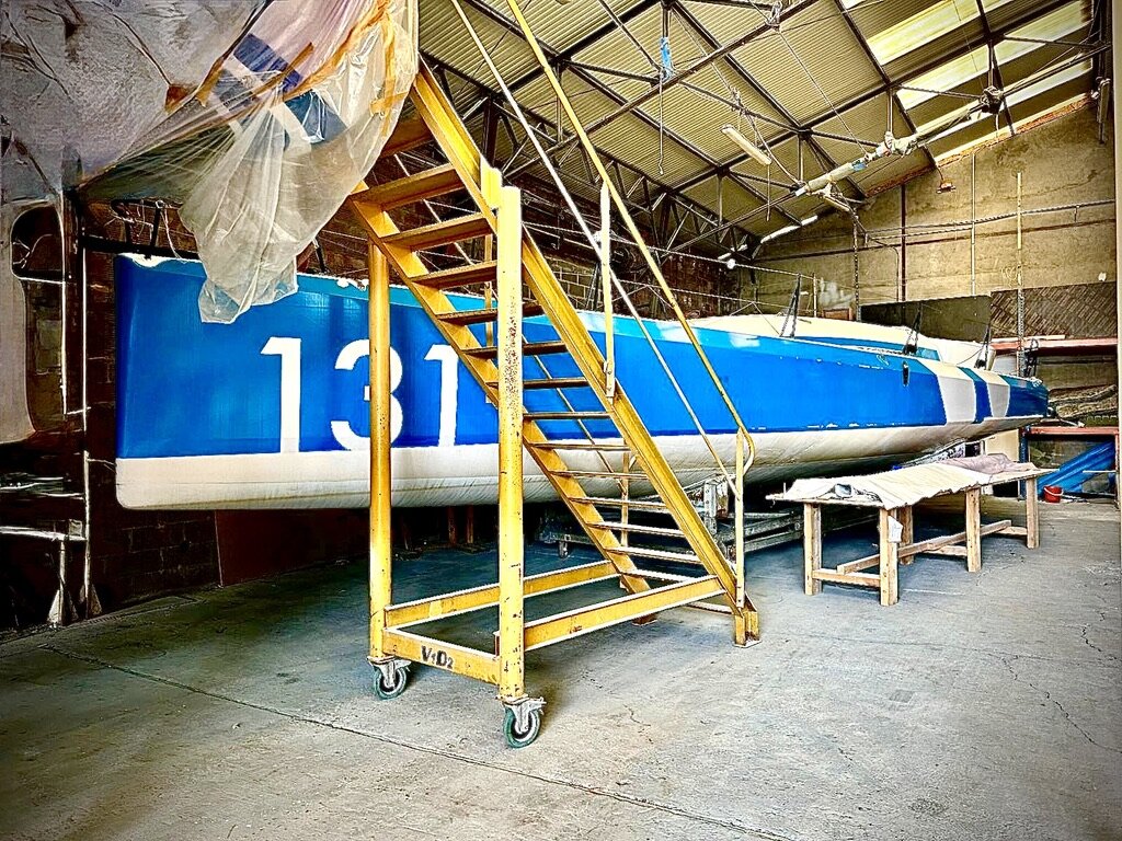Guerrera's hull in primer inside the V1D2 hangar, sail number 131 visible